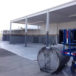 Outdoor facility undergoing painting and epoxy floor preparation