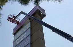 Commercial painting services on a shopping center pylon